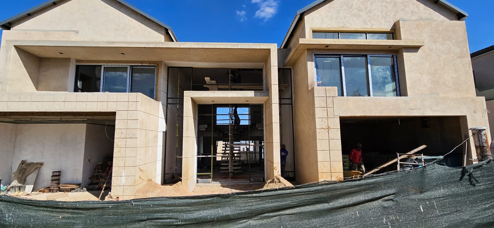 Site team on scaffolding constructing the upper storey of a new home