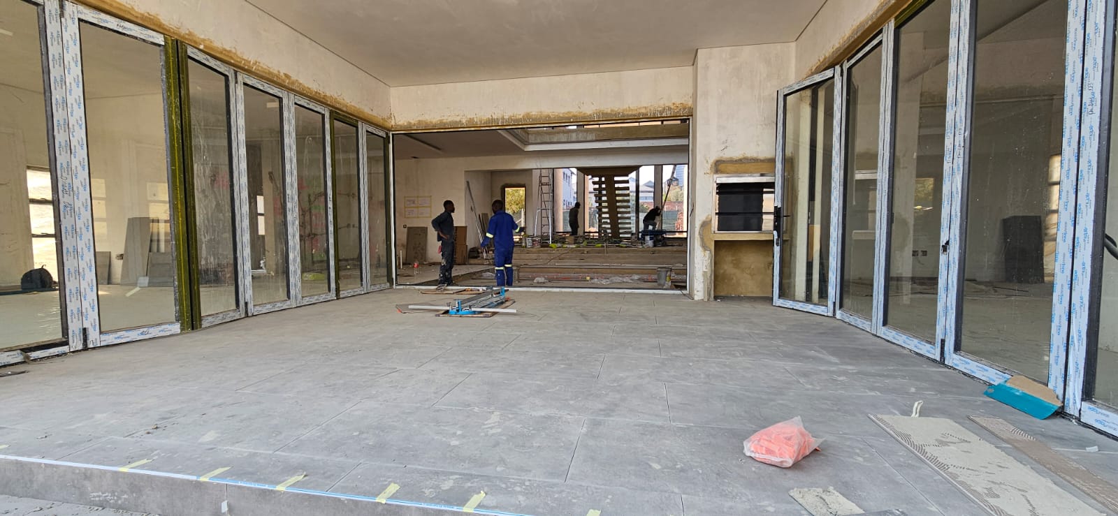 Front entrance of a home under construction with glazing being installed